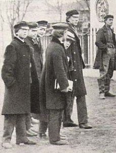 en klunga unga män i uniformsliknande kappor