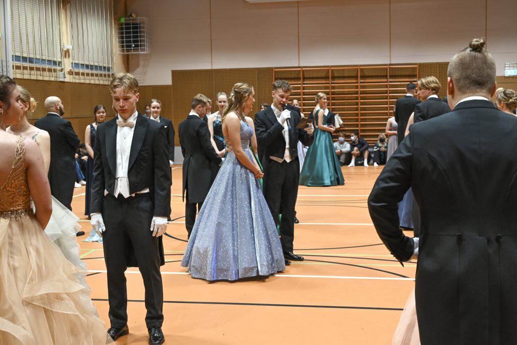 Inne i gymnastiksalen, konferenciererna hälsar gästerna välkomna