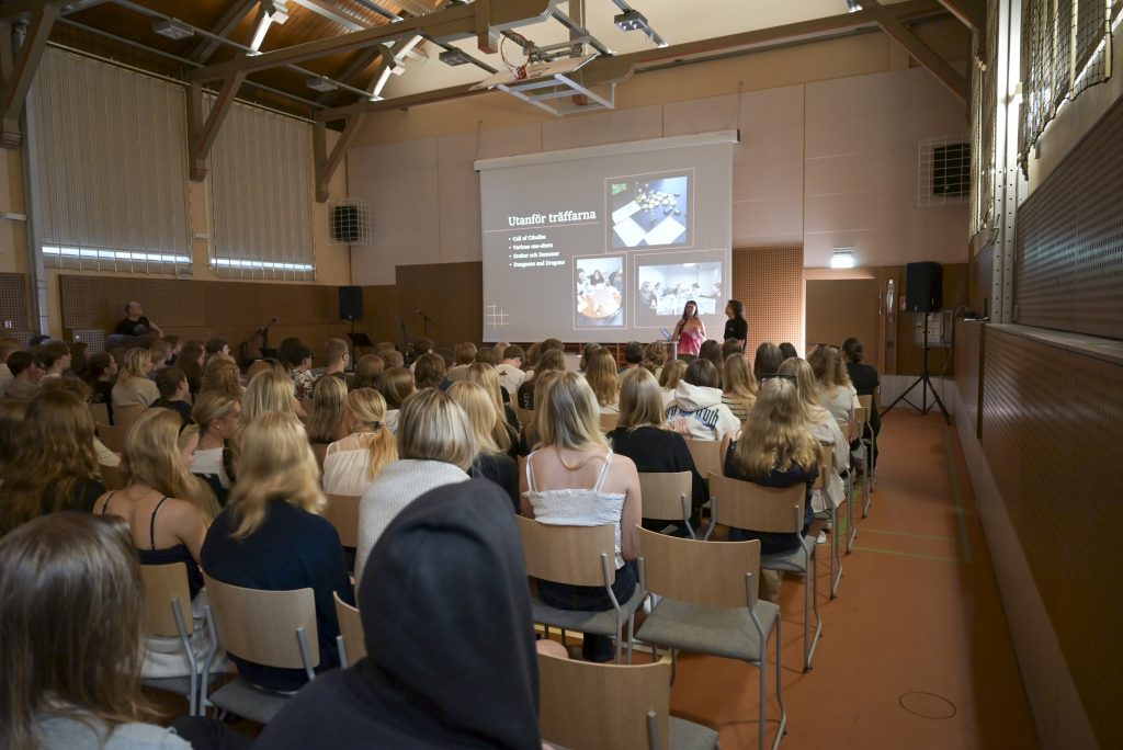 gymnastiksalen full av ungdomar som sitter och lyssnar