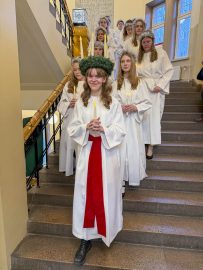 Lucia med följe kommer ner för trappan i skolan