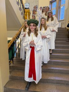 Lucia med följe kommer ner för trappan i skolan