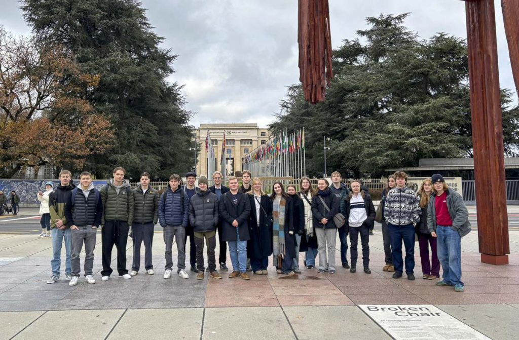 en grupp studerand står i en park