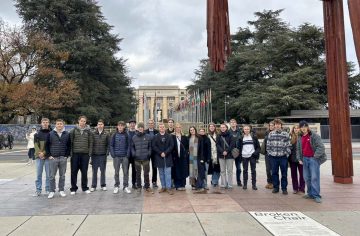 en grupp studerand står i en park