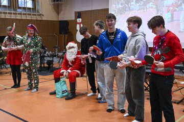 studerande på julfest tillsammans med jultomten